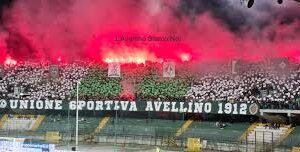 spalti stadio con fumogeni rosa e striscione Unione sportiva Avellino 1912